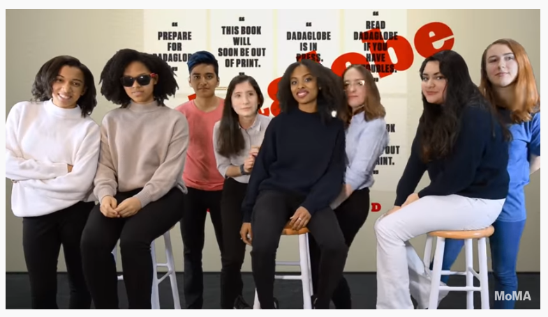 Image still from video that captures all 8 members of the MoMA Teens Digital Advisory Board of 2016 standing in front of a green screen with an archival image of the Dadaglobe project projected on it. 3 members are seated on white stools while the rest are standing in between them.